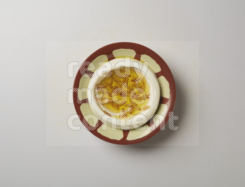 Lebnah garnished with pine nuts in a traditional plate on a white background
