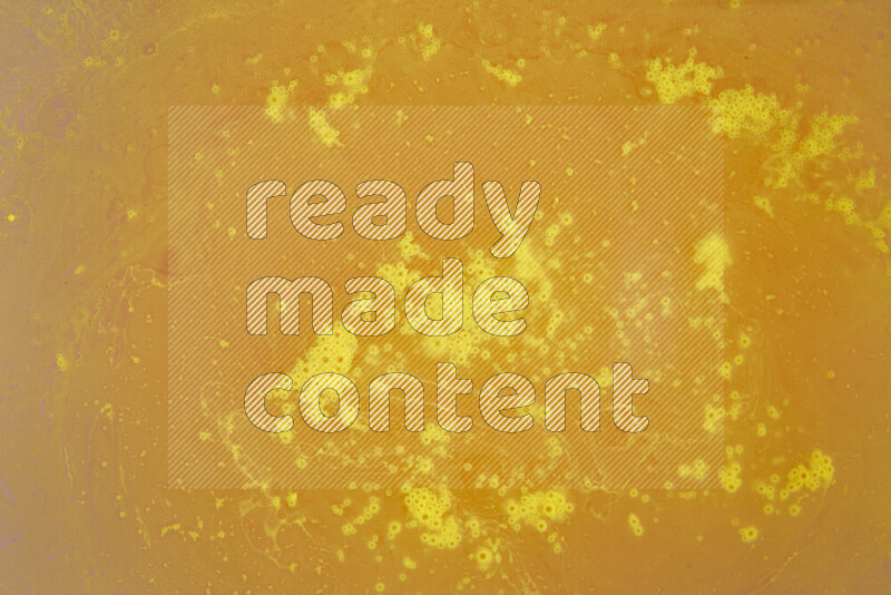 The image captures a dramatic splatter of yellow paint over a white backdrop
