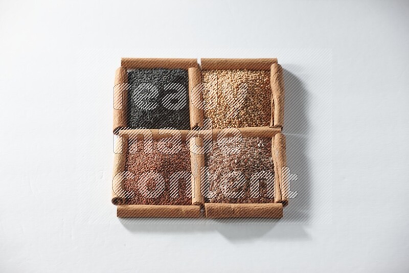 4 squares of cinnamon sticks full of black seeds, mustard seeds, flaxseeds and garden cress on white flooring