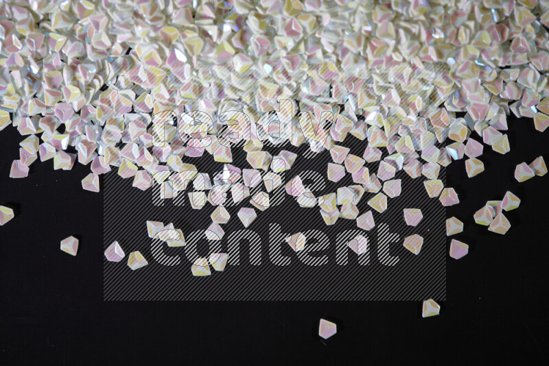 Colorful plastic shards for decoration scattered on a black background