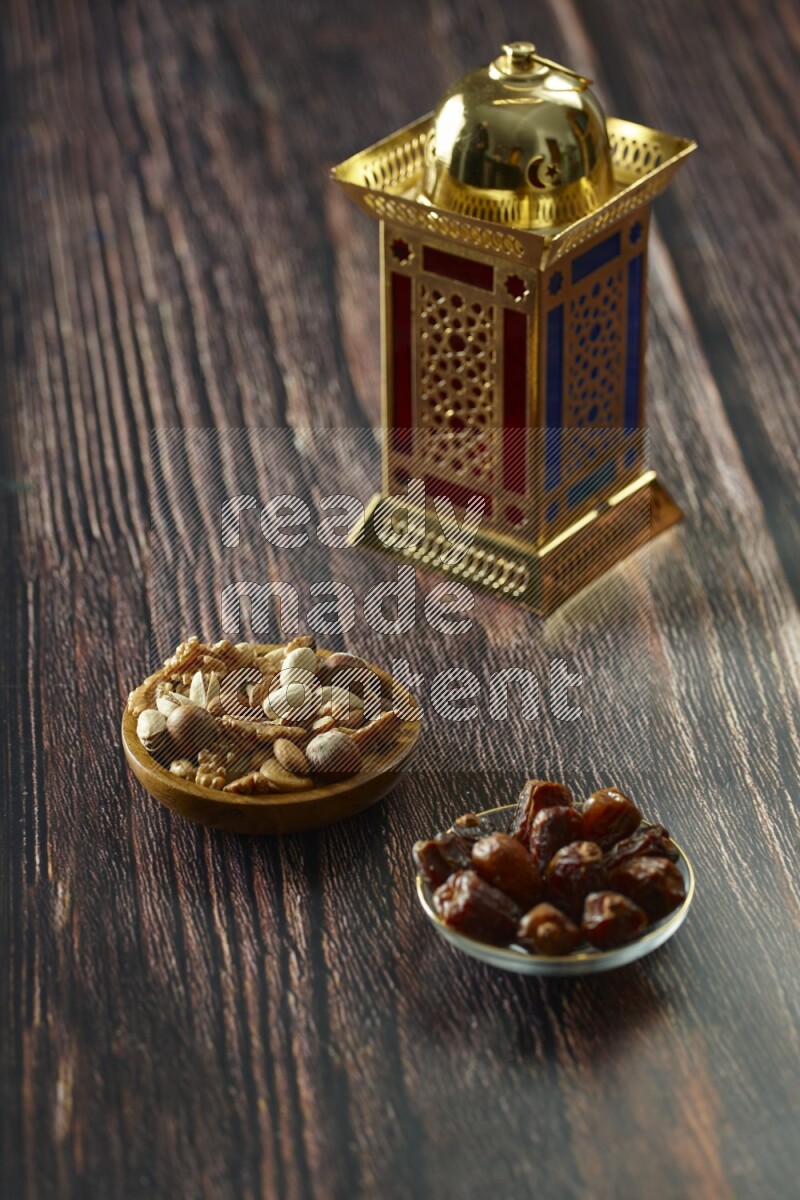 A golden lantern with different drinks, dates, nuts, prayer beads and quran on brown wooden background