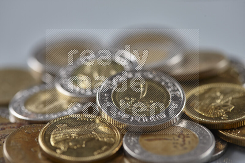 A close-up of scattered mixed Egyptian coins such as One pound, 50 and 25 piasters on grey background