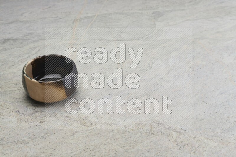 A multicolored pottery bowl on grey marble background
