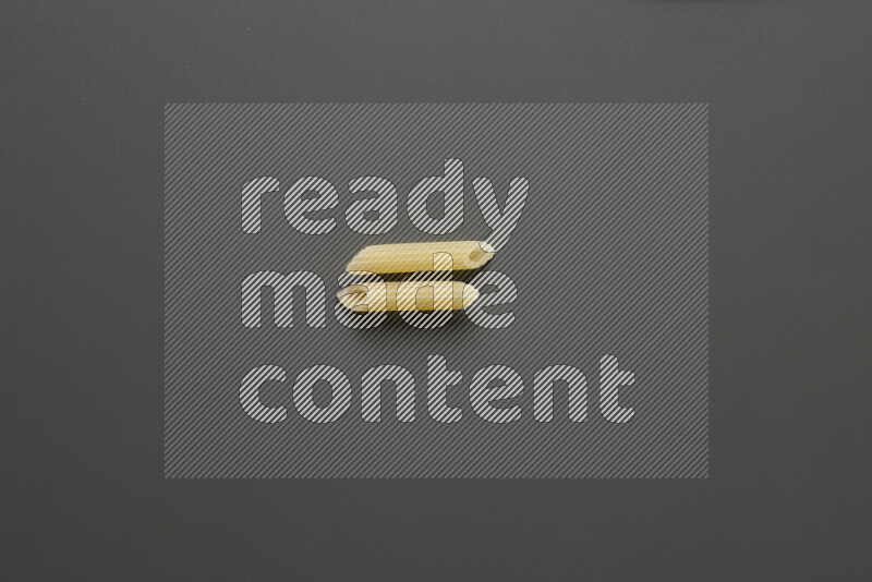Mini penne pasta on grey background