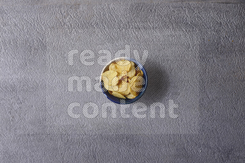 Assorted snacks in pottery bowls on grey background