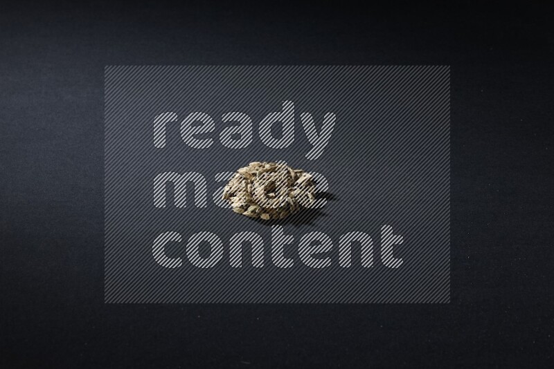 Cardamom in a circle shape on black flooring