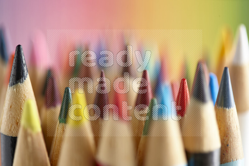 The image captures a close-up of sharpened colored pencils on multicolored background