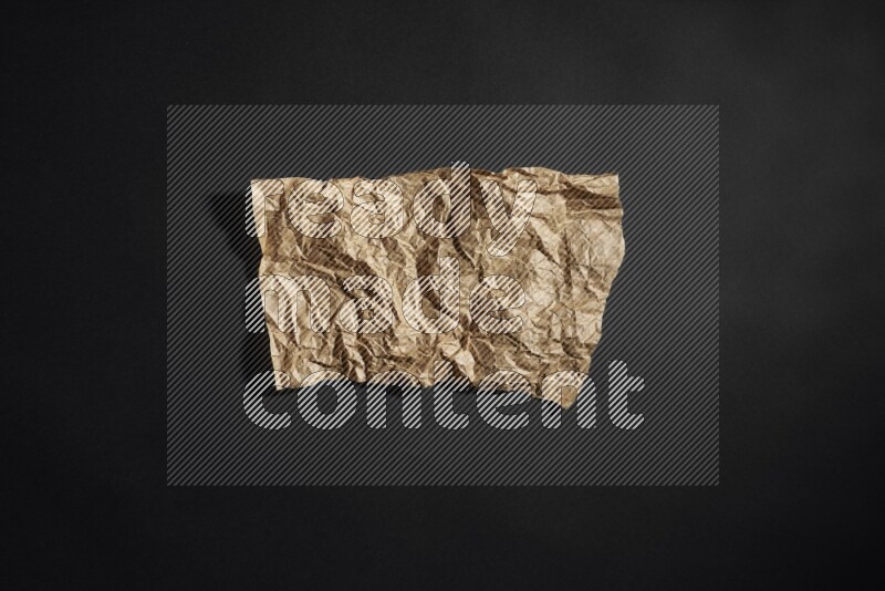 Crumpled craft paper on black background