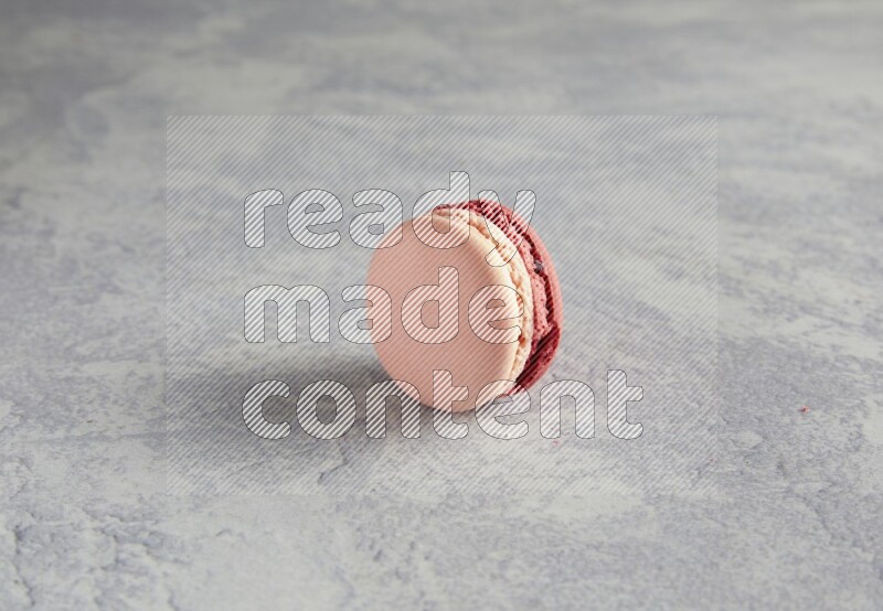 45º Shot of Pink Litchi Raspberry macaron on white  marble background