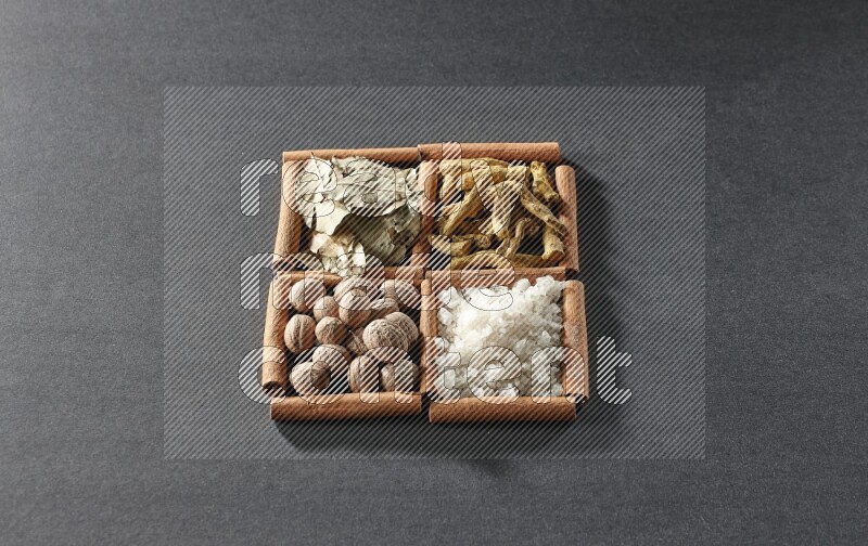4 squares of cinnamon sticks full of bay laurel leaves, white salt, turmeric fingers and nutmegs on black flooring