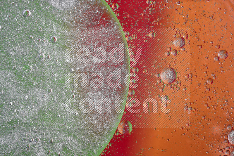 Close-ups of abstract oil bubbles on water surface in shades of orange, green and red