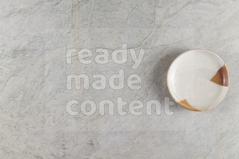 صحن فخاري مزخرف على خلفية من الرخام الرمادي