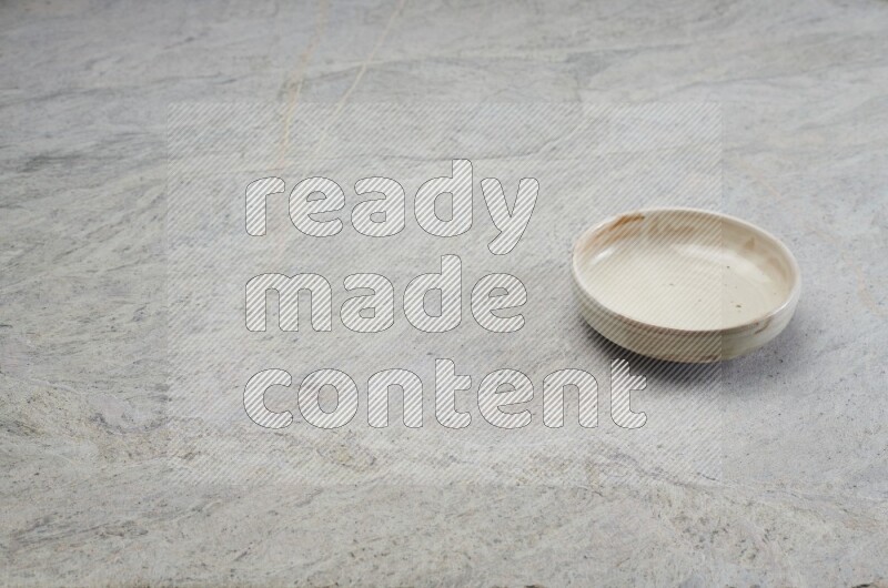 A multicolored pottery bowl on grey marble background