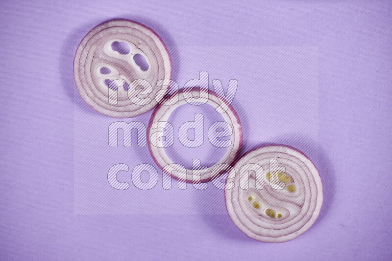 Red onions rings on purple background