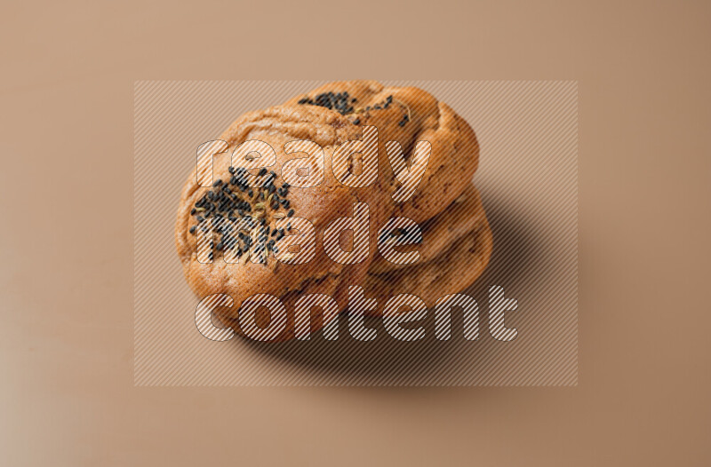 Hasawi cookies field with date and decorated by black seed and Anise grain on a brown background