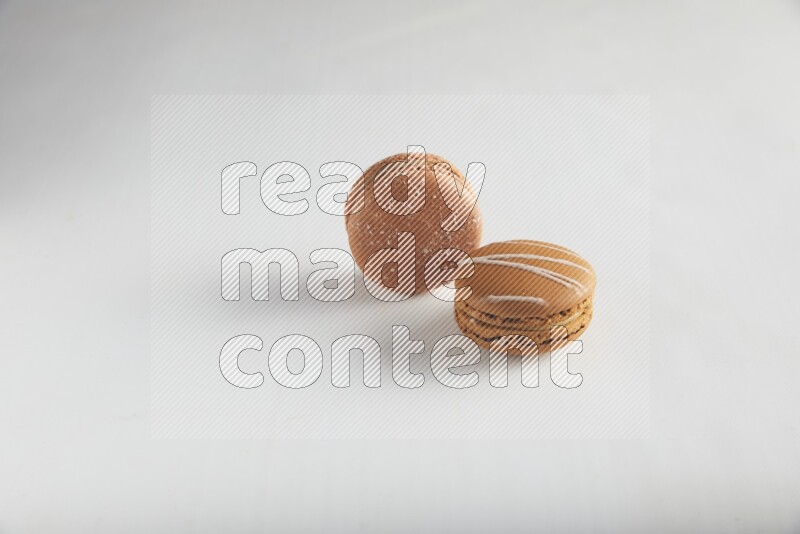 45º Shot of of two assorted Brown Irish Cream, and Brown Hazelnuts macarons on white background