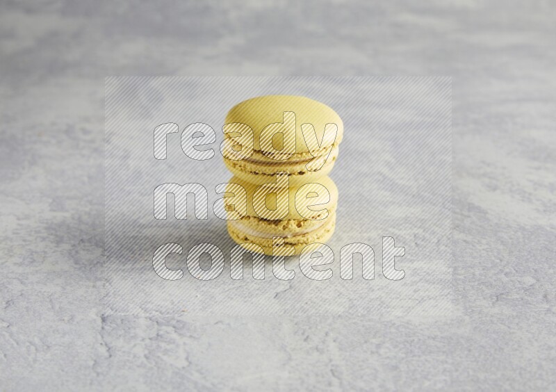 45º Shot of two Yellow Lime macarons  on white  marble background