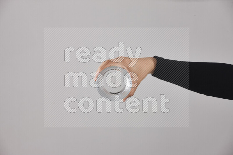 A woman in black abaya holding different glassware in different positions
