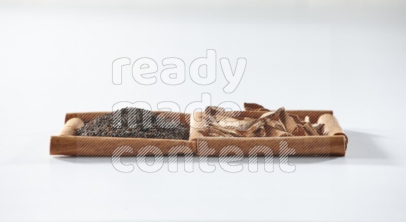 2 squares of cinnamon sticks full of black tea and cinnamon on white flooring