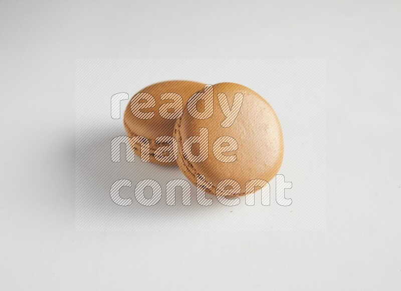45º Shot of two Brown Maple Taffy macarons on white background