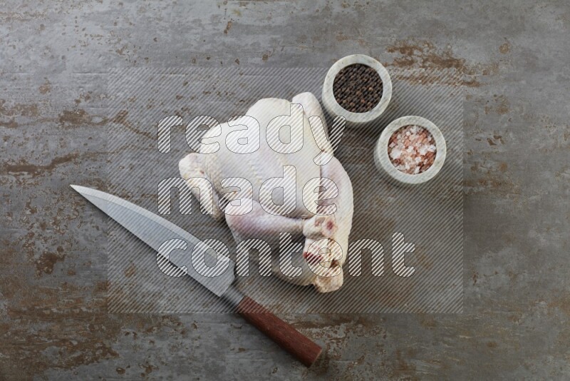 whole raw chicken  direct on a rustic grey background