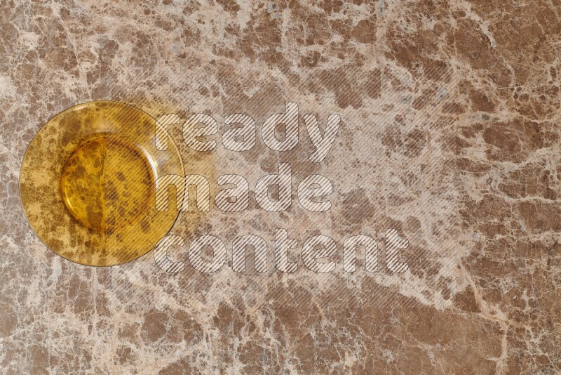 A circular glass plate on beige marble background