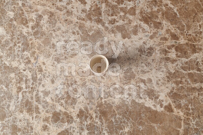 A pottery cup on beige marble background