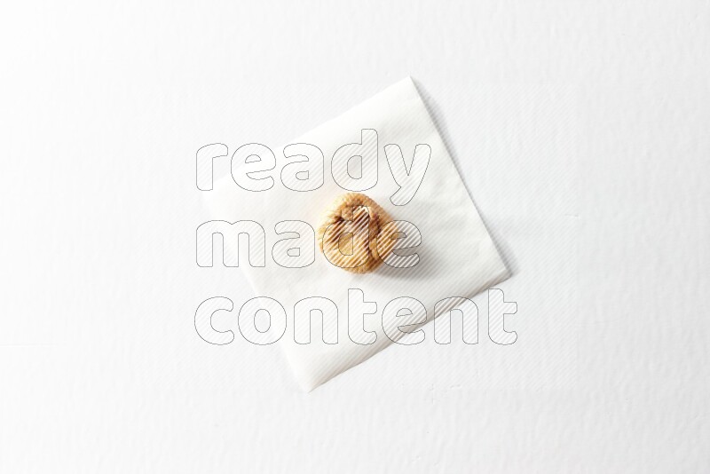 A dried fig on a piece of paper on a white background in different angles