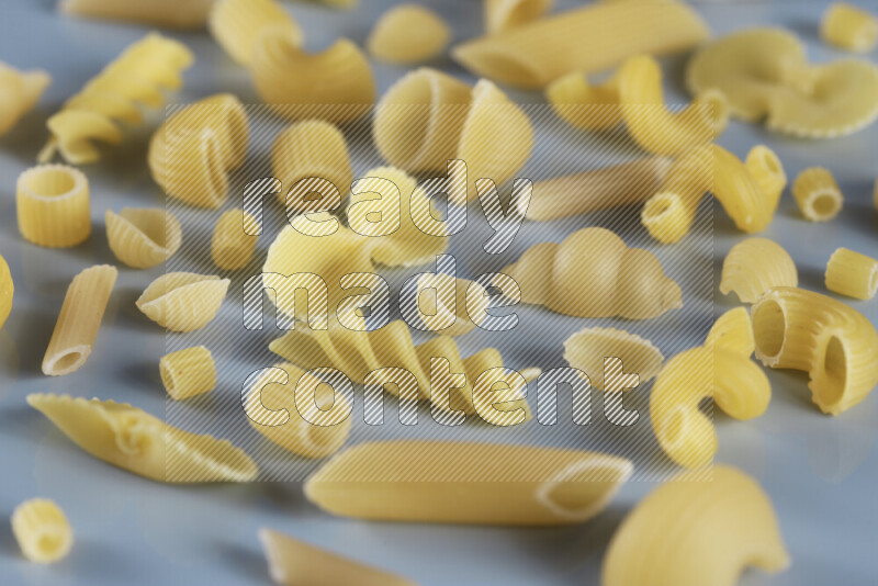 Different pasta types on light blue background