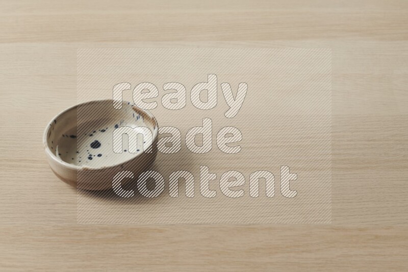 A multicolored pottery plate on light wooden background