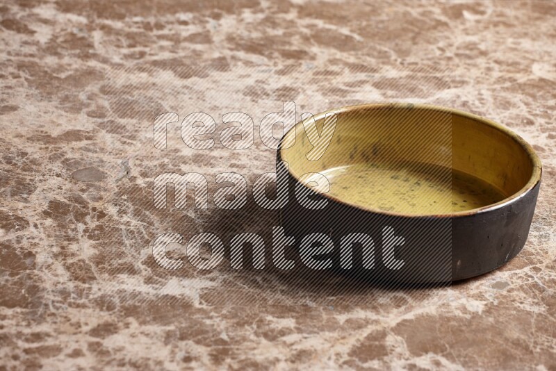 A multicolored pottery oven plate on beige marble background