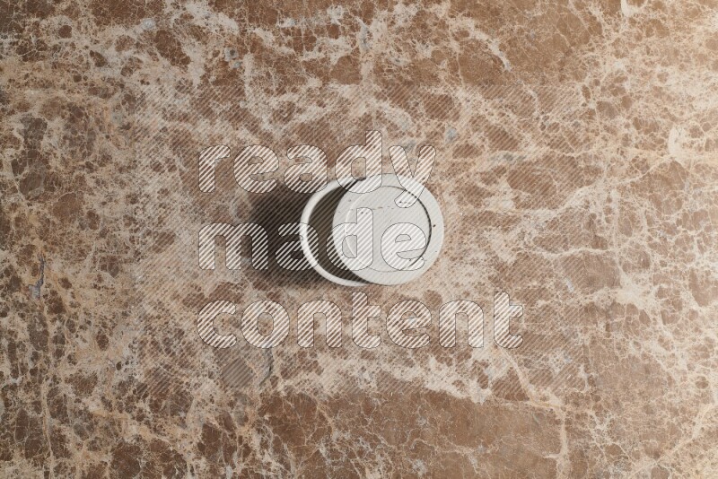 A pottery cup on beige marble background