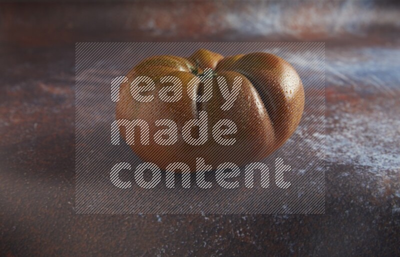 45 degree single heirloom tomato on  a textured reddish rustic metal background