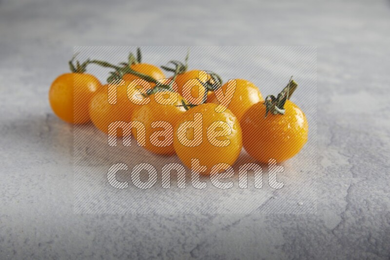 Yellow cherry tomato vein on a light grey textured background 45 degree