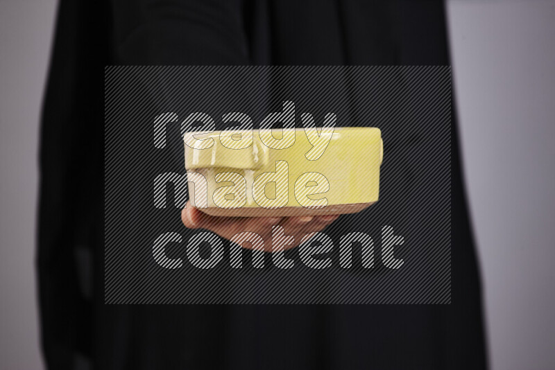 امرأة ترتدي عباءة سوداء تحمل أدوات فخارية مختلفة في أوضاع متعددة