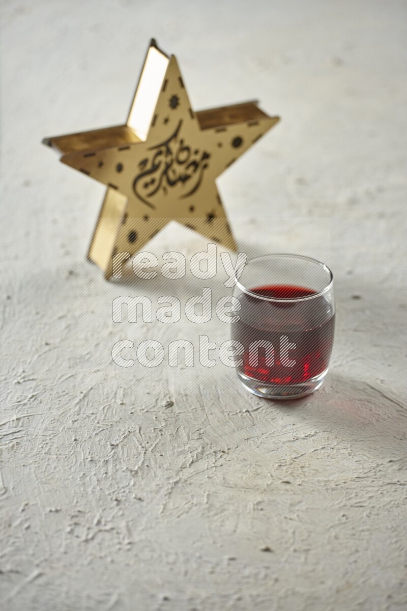 A wooden golden star lantern with different drinks, dates, nuts, prayer beads and quran on textured white background