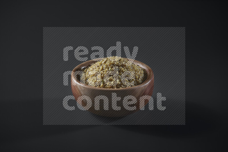 Coarse bulgur in a wooden bowl on grey background