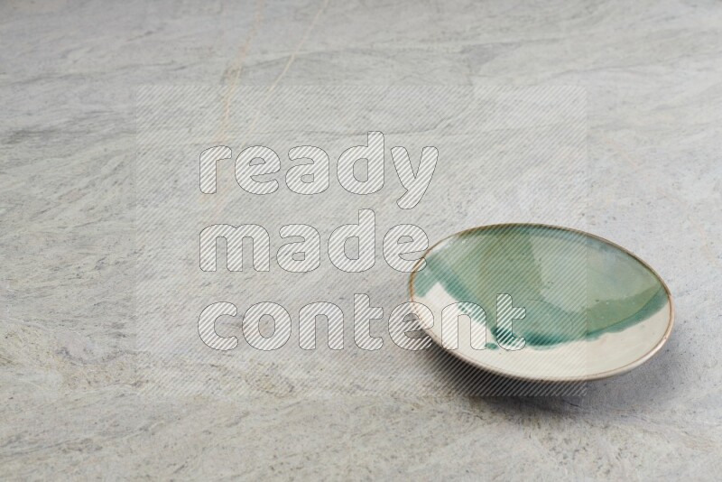 A multicolored pottery plate on grey marble background