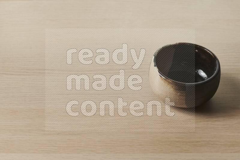 وعاء فخاري متعدد الألوان على خلفية خشبية فاتحة