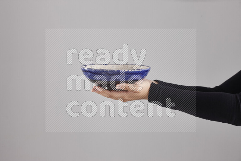 امرأة ترتدي عباءة سوداء تحمل أدوات فخارية مختلفة في أوضاع متعددة