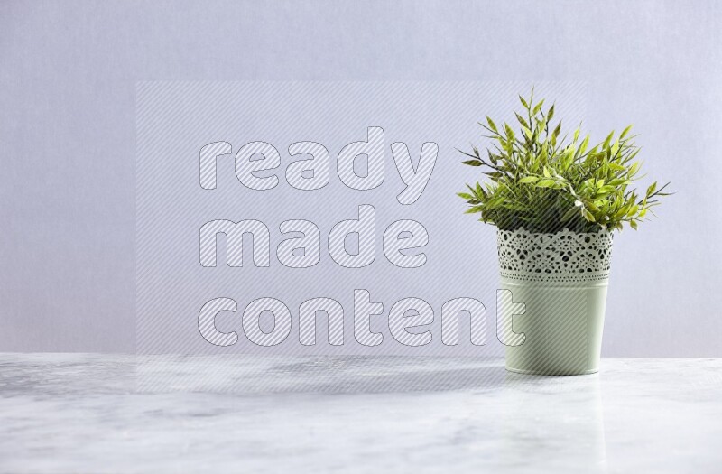 Artificial plant in green decorative pot on grey marble background