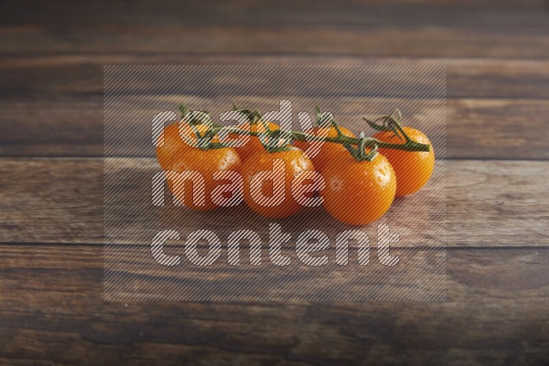 Orange cherry tomato vein on a textured wooden background 45 degree
