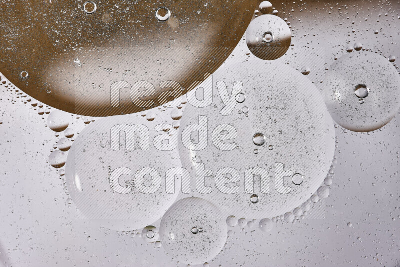 لقطات مقربة لفقاعات من الزيت على سطح الماء باللون الأبيض والبني