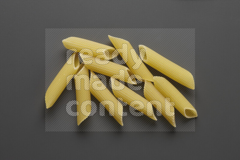 Penne pasta on grey background