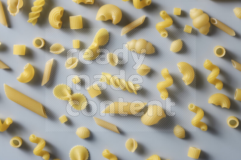 Different pasta types on light blue background