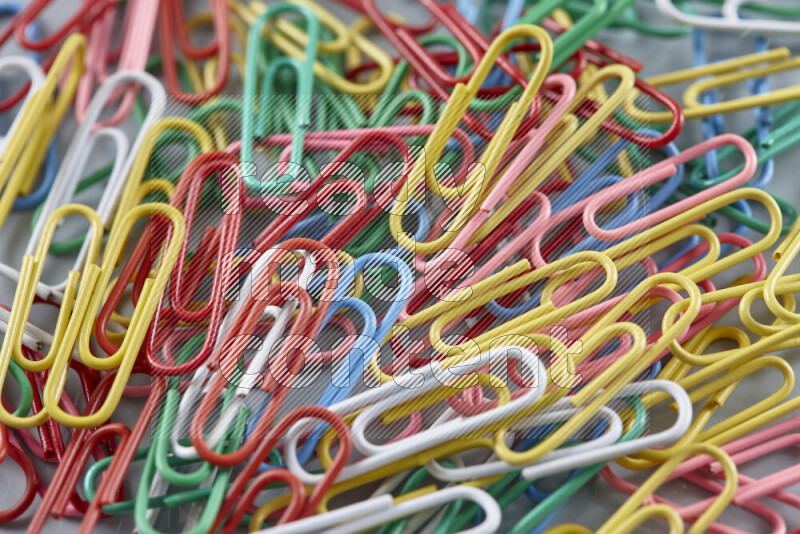 Multicolored paper clips isolated on a grey background