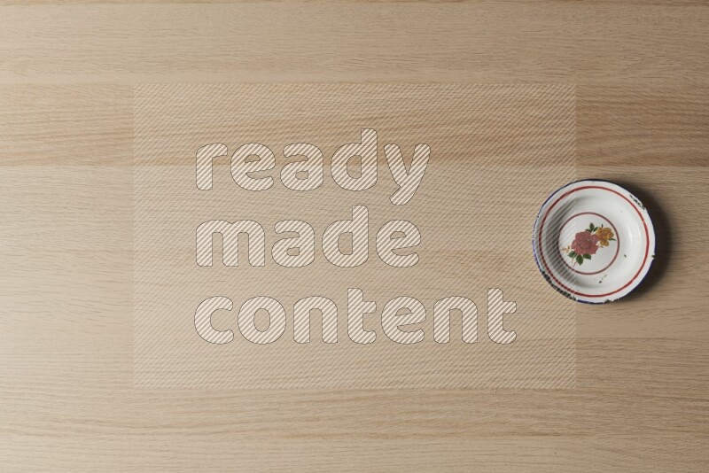 A vintage metal plate on light wooden background