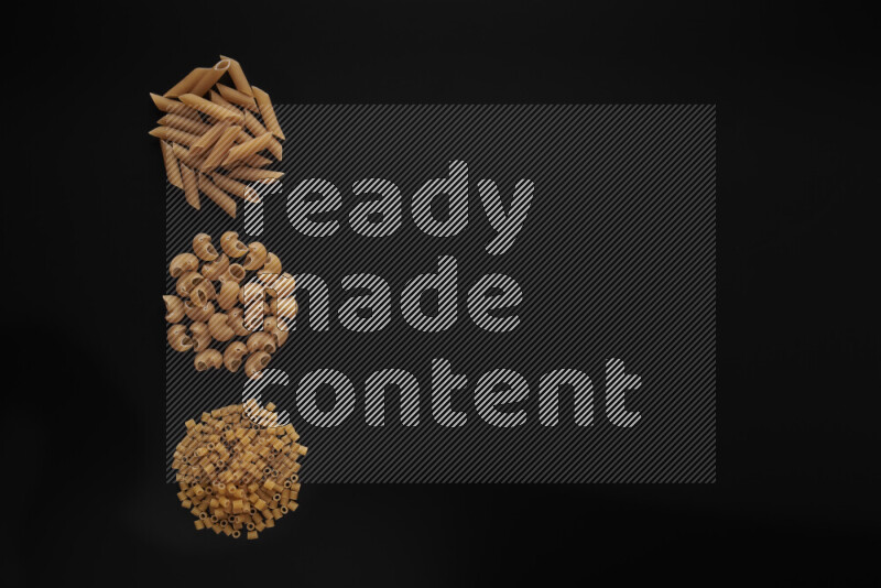 Different pasta types in 3 bunches on black background