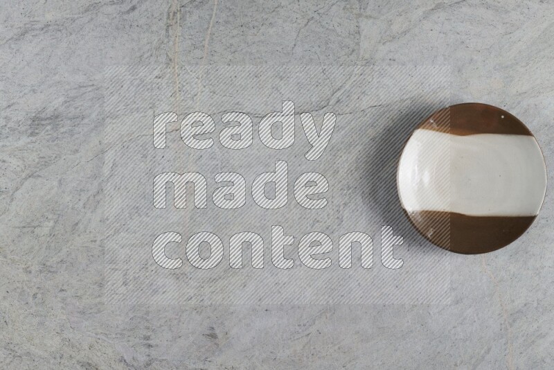 A multicolored pottery plate on grey marble background