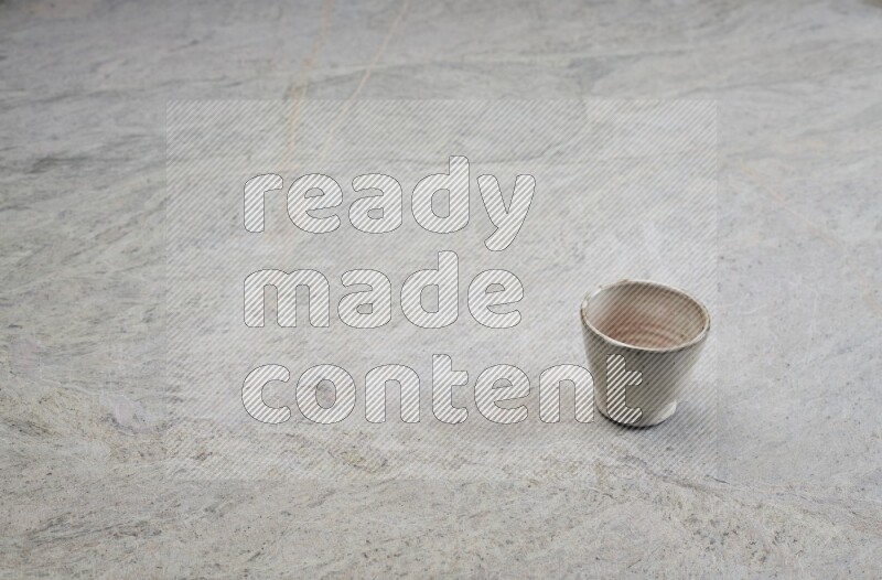 A multicolored pottery Cup on grey marble background
